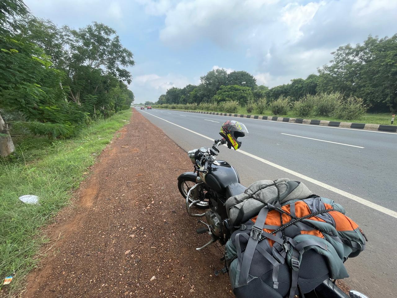 A bike parked on the crub with mountains in tha back.
